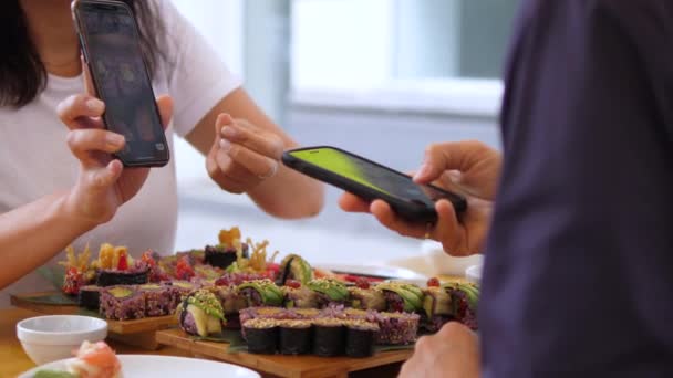 Ételblogolás. A lány képeket mutat a sushi-ról, amit a barátjának vitt. Kézműves japán konyha — Stock videók