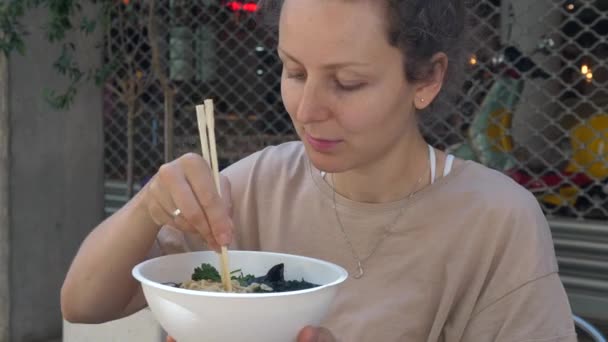Zdravá veganská asijská kuchyně. Hladové běloška dívka jíst vegan ramen polévka s velkým potěšením. — Stock video