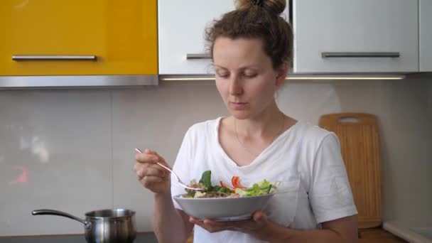 젊은 여성 이 부엌에서 건강에 좋은 음식을 먹고 있습니다. 집에서 만든 건강 한 식품. — 비디오