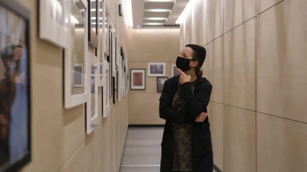 Young woman walking in art gallery enjoying paintings during covid-19 pandemic — Stock Video