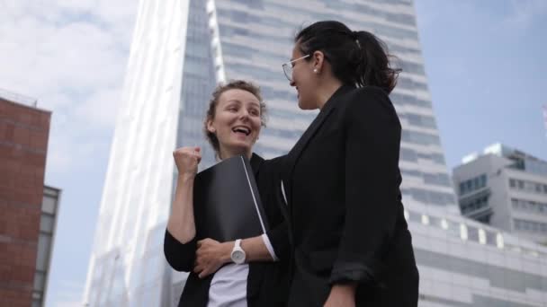 Két boldog, szakmailag elégedett, különböző etnikai hátterű női vezető irodaépületek előtt. — Stock videók