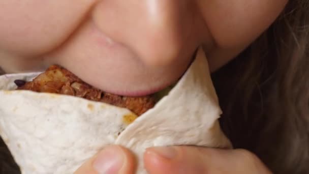 Mulher nova comendo fast food mordendo Burrito Vegan com legumes. Fechar da boca feminina. — Vídeo de Stock