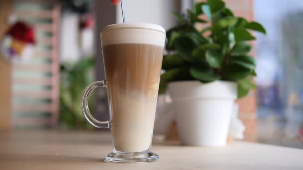 Míchání horké kávy Latte na dřevěném stole v kavárně. — Stock video