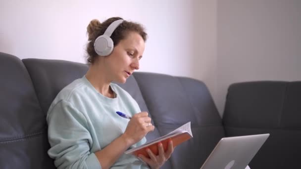 Close up de estudante do sexo feminino desfrutando de educação remota a partir de dispositivos domésticos. Conceito de auto-isolamento do coronavírus — Vídeo de Stock