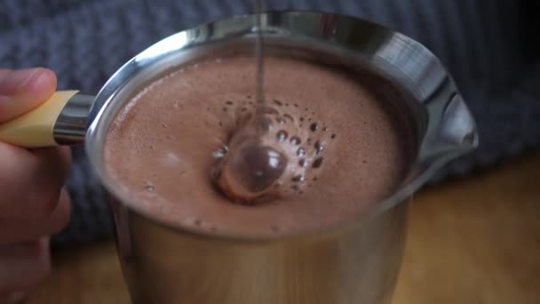 Mezclando chocolate caliente en una jarra de acero. Concepto de alimento reconfortante — Vídeo de stock