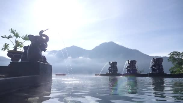 Natuurlijke hete bron Toya Devasya naast Batur vulkaan. Oneindig zwembad met olifantenfiguren. Populaire reisbestemming — Stockvideo