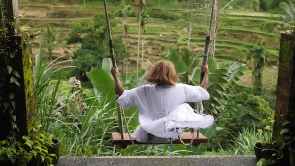 Baksidan av en kvinna på en berömd Balinesisk ris terrass gungor — Stockvideo