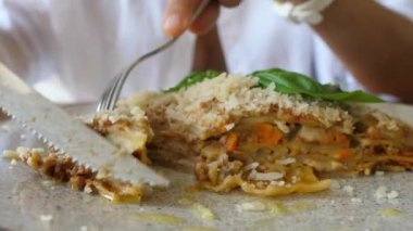 Vegan versiyonunda geleneksel İtalyan mutfağı. Bir insan lazanya bazlı bir bitkiyi keser ve kameraya gösterir.