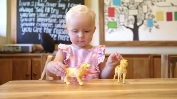 Blondýny batole dívka hrát s hračkou zvířata v jeslích — Stock video