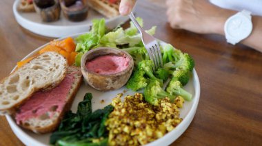 Pancar sosuna çatal batıran brokoli. Sebze ve bitki bazlı proteinlerle dolu sağlıklı dengeli vejetaryen yemekleri.