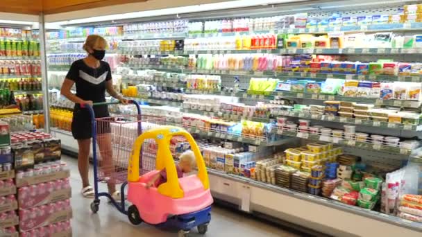 在covid-19大流行期间，中年妇女带着一个婴儿在玩具车里购物。巴厘-2021年5月 — 图库视频影像