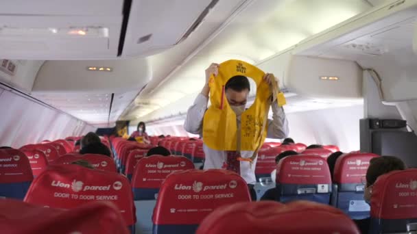 The Flight attendant shows the passengers how to use an inflatable life vest in the emergency landing. Safety instructions concept.Bali-June-2021 — Stock Video