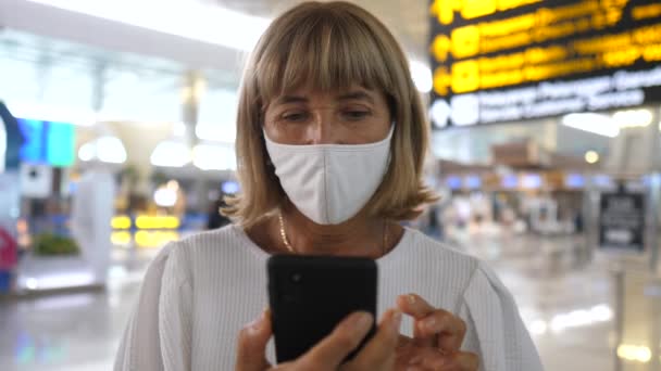 Nová pravidla pro cestování letadlem způsobená epidemií COVID-19. Žena v masce na letišti — Stock video