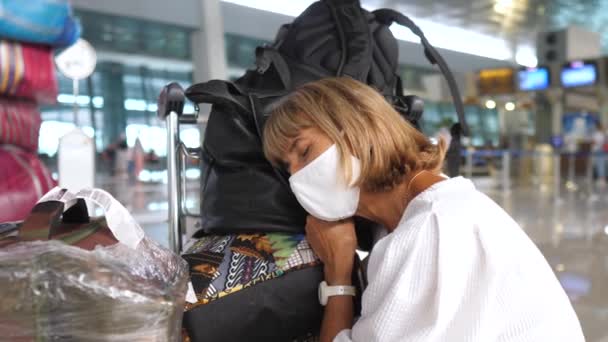 Жінка заснула на багажі під час очікування літака. Тривале очікування на з'єднання — стокове відео