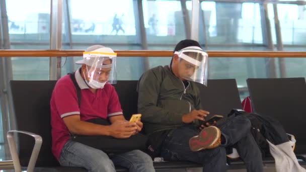 Men in face masks sitting at the waiting room at the station. Bali-June-2021 — Stock Video