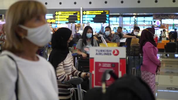 Perfil de uma mulher caucasiana usando máscara protetora esperando na fila para embarcar em seu voo. Restrições de segurança no aeroporto. Bali-Junho-2021 — Vídeo de Stock