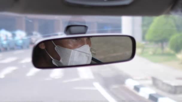 Reflexão em um espelho retrovisor de um motorista asiático usando uma máscara facial durante a pandemia do covid-19. Bali-Junho-2021 — Vídeo de Stock