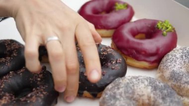 Bir el, kutudan sağlıklı organik bir donut seçiyor..