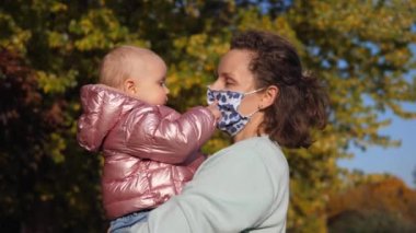 Covid 19 salgını sırasında sonbahar yürüyüşleri. Beyaz, tatlı bir bebek annesinin maskesini yırtıp atıyor.