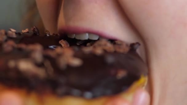 Закройте рот женщины, поедающей веганский пончик с шоколадной глазурью — стоковое видео