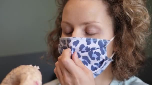 Κοντινό πλάνο μιας γυναίκας που βγάζει τη μάσκα του προσώπου της για να φάει ένα νόστιμο vegan ντόνατ — Αρχείο Βίντεο