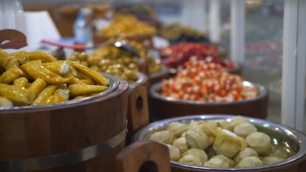 Selezione di cibo in salamoia mediorientale esposto in bidoni su un mercato alimentare fresco — Video Stock