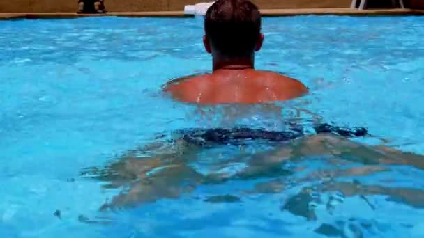 Young gebruinde gespierde Man zwemmen in blauwe zwembad in Slow Motion. — Stockvideo