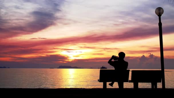 Man neemt foto van prachtige zonsondergang. — Stockvideo