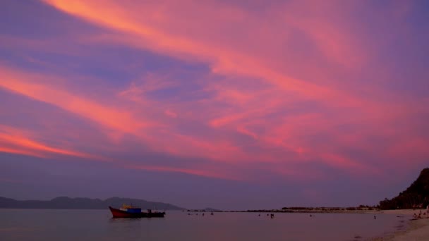 Personnes nageant près de Bateau de pêche au coucher du soleil — Video