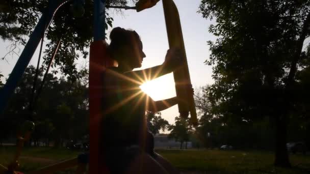 Silhouet van de vrouw fitnesstraining bij zonsondergang. Slow Motion. — Stockvideo