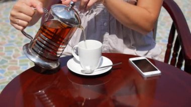 Erkek'de Cafe açık havada tabloda çay cep telefonu ile içme.