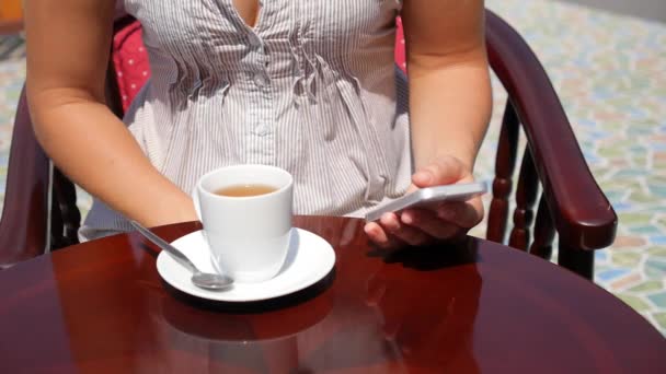 Fiatal nő segítségével a telefon, és ivott Tea Cafe — Stock videók