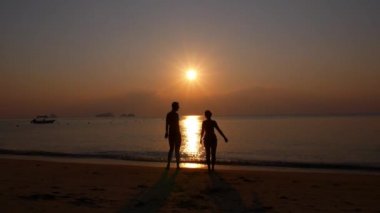 Mutlu neşeli çift zevk Sunset Beach silah kaldırdı ile