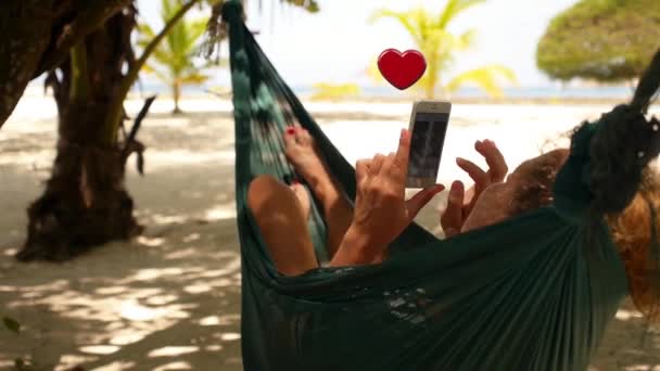 Mujer sosteniendo teléfono inteligente Relajarse en una hamaca y conseguir símbolos del corazón de animación. Recogido Likes Concepto . — Vídeos de Stock