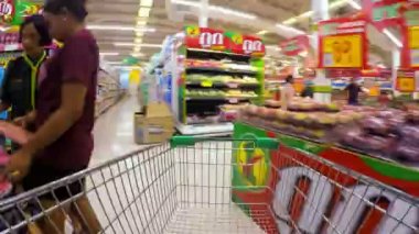 Tayland, Koh Samui, 05.25.2015: Alışveriş erkeklerle süpermarket rafları ile taşıma sepeti ve gıda sepete koy