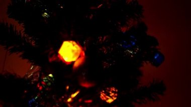 Gecenin içinde bir ağaçta asılı Noel ışıkları.