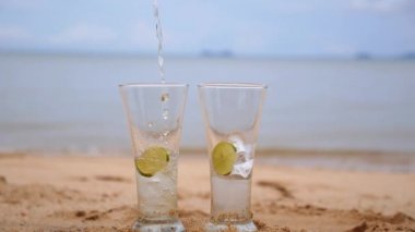 Sahilde bardaklarda buzlu soğuk çay limon dilimleri ile dökme.