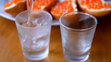 İki kadeh votka ve kırmızı havyar sandviçle buğulu.