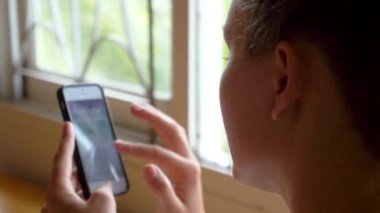 Kadının elinde cep telefonu.