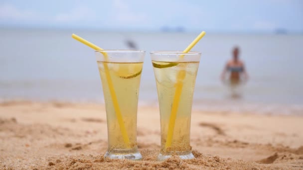 Dos jugos frescos tropicales en la playa con chica en bikini . — Vídeo de stock