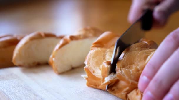 Mujer cortando un pan con cuchillo en la cocina — Vídeos de Stock