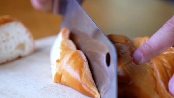 Hände schneiden Brotlaibe mit einem Messer. Nahaufnahme. — Stockvideo