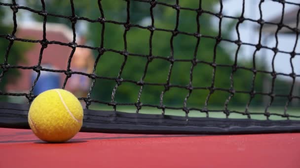 Pelota de tenis en la cancha Cierre con la red más allá — Vídeo de stock