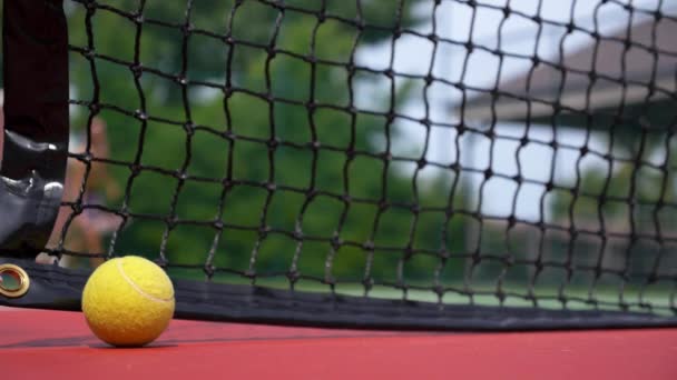 Tennisball auf dem Platz mit dem Netz im Hintergrund — Stockvideo