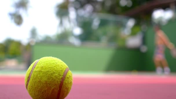 Pelota de tenis en la cancha Primer plano con fondo de jugador de tenis . — Vídeos de Stock
