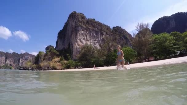 Jeune femme courant dans la mer en vacances. Mouvement lent . — Video