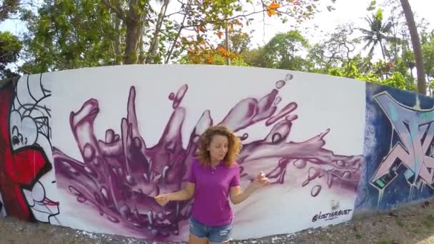 Thailand, Koh Samui, februari 2015 - Happy mooie vrouw dansen in de buurt van Graffiti muur. Slow Motion. — Stockvideo