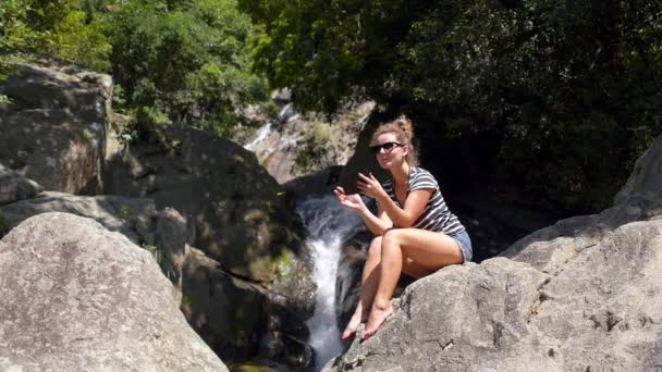 Atrakcyjna kobieta za pomocą tabletu odkryty w pobliżu wodospadu — Wideo stockowe