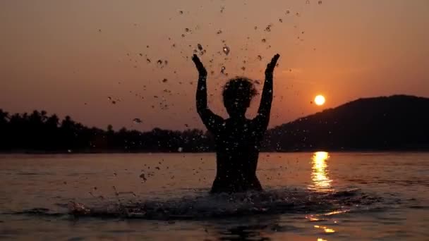 Silueta de mujer en el mar disfrutando de la puesta del sol. Moción lenta . — Vídeos de Stock