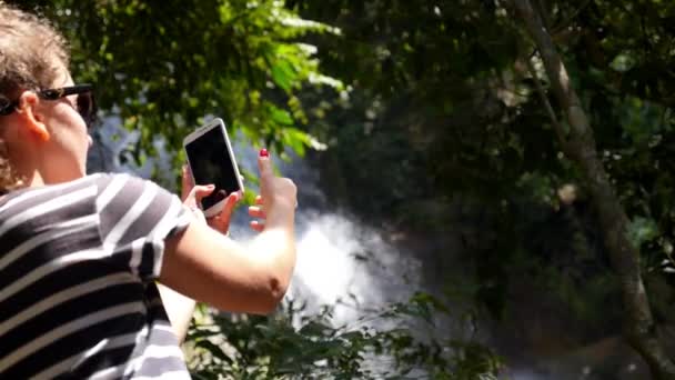 Mujer tomando fotos usando el teléfono inteligente en el parque — Vídeos de Stock